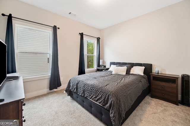 carpeted bedroom featuring visible vents and baseboards