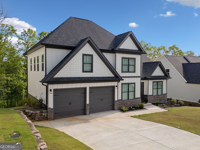 view of front of property featuring roof with shingles, a front lawn, concrete driveway, a garage, and board and batten siding