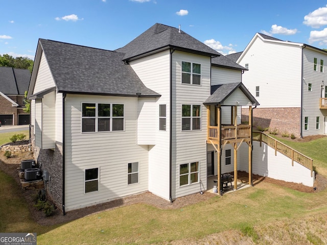 rear view of house featuring central AC unit, a shingled roof, a patio area, a lawn, and a deck