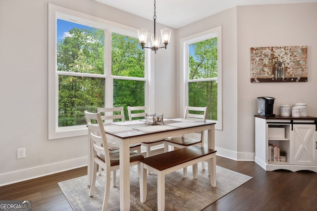 dining room featuring an inviting chandelier, dark wood-style flooring, and baseboards