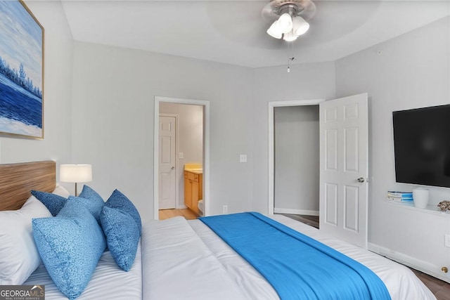bedroom featuring light wood-style flooring, a ceiling fan, and ensuite bathroom