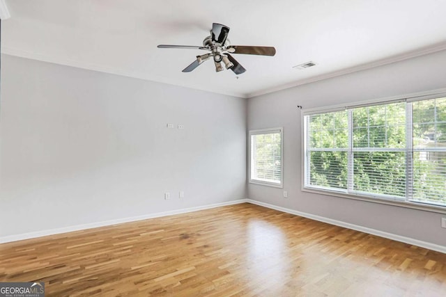 unfurnished living room with ornamental molding, ceiling fan with notable chandelier, light wood-type flooring, and plenty of natural light