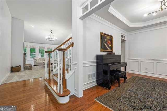 7045 Mountain Xing, Cumming, GA 30041 - entryway with wainscoting, a towering ceiling, wood finished floors, stairs, and a decorative wall