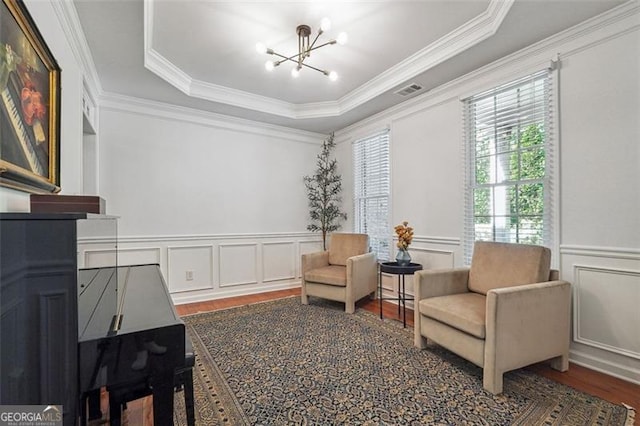 7045 Mountain Xing, Cumming, GA 30041 - sitting room with a raised ceiling, wood finished floors, ornamental molding, a decorative wall, and a chandelier