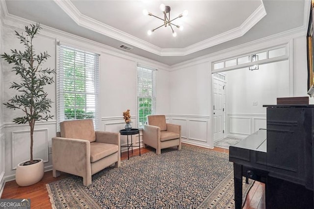 7045 Mountain Xing, Cumming, GA 30041 - sitting room with a raised ceiling, wood finished floors, ornamental molding, a decorative wall, and a chandelier