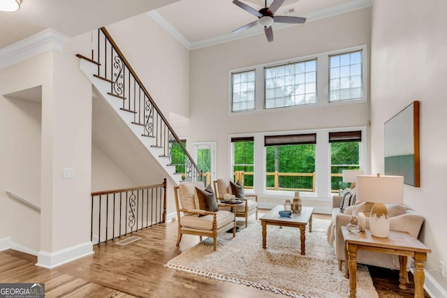1400 Squire Ln, Cumming, GA 30041 - living area featuring crown molding, wood finished floors, a ceiling fan, and a towering ceiling