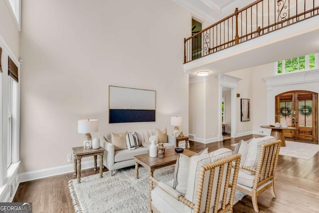 1400 Squire Ln, Cumming, GA 30041 - living area featuring arched walkways, wood finished floors, a towering ceiling, and baseboards