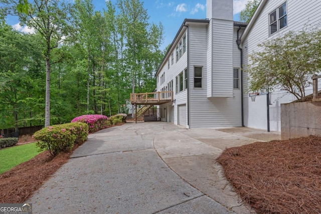 1400 Squire Ln, Cumming, GA 30041 - view of home's exterior with a chimney, stairs, a wooden deck, driveway, and a garage