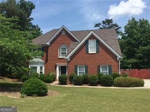 990 Lilac Arbor Rd, Dacula, GA 30019 - view of front of property featuring fence, an attached garage, brick siding, a front yard, and concrete driveway