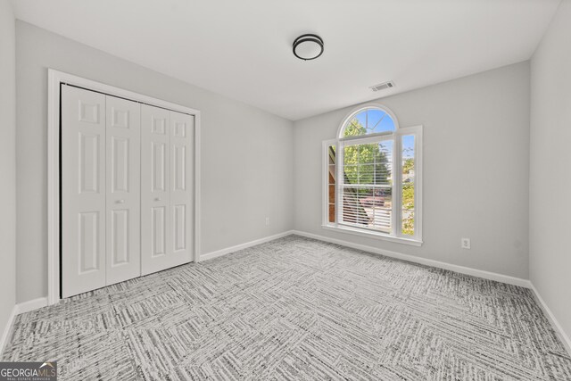 990 Lilac Arbor Rd, Dacula, GA 30019 - unfurnished bedroom with baseboards, visible vents, carpet, and a closet