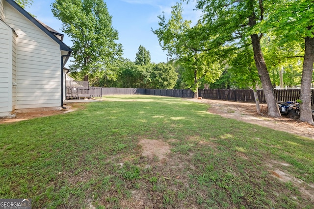 990 Lilac Arbor Rd, Dacula, GA 30019 - back of property featuring a chimney, a lawn, a deck, a fenced backyard, and a shingled roof