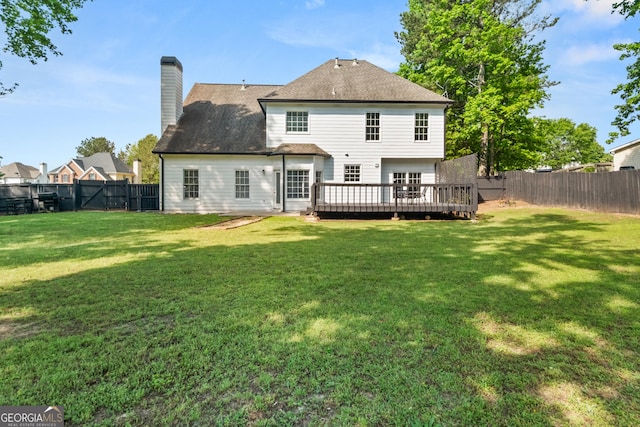 990 Lilac Arbor Rd, Dacula, GA 30019 - back of property featuring a chimney, a lawn, a deck, a fenced backyard, and a shingled roof