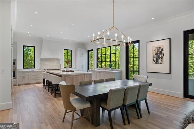 dining room with recessed lighting, light wood-style floors, and an inviting chandelier