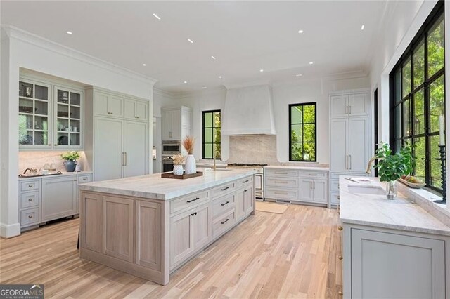 kitchen featuring backsplash, stainless steel range, and a healthy amount of sunlight