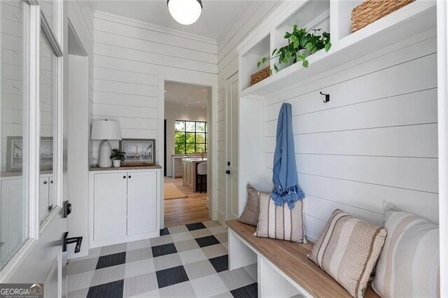 mudroom featuring wooden walls and light floors