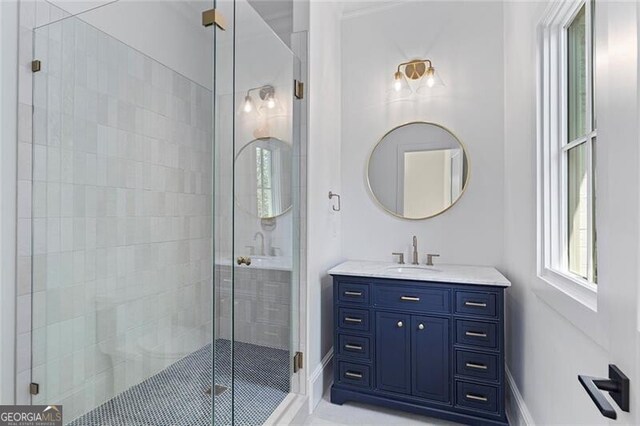 full bath with baseboards, a shower stall, and vanity
