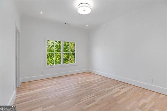 unfurnished room with baseboards, wood finished floors, and ornamental molding