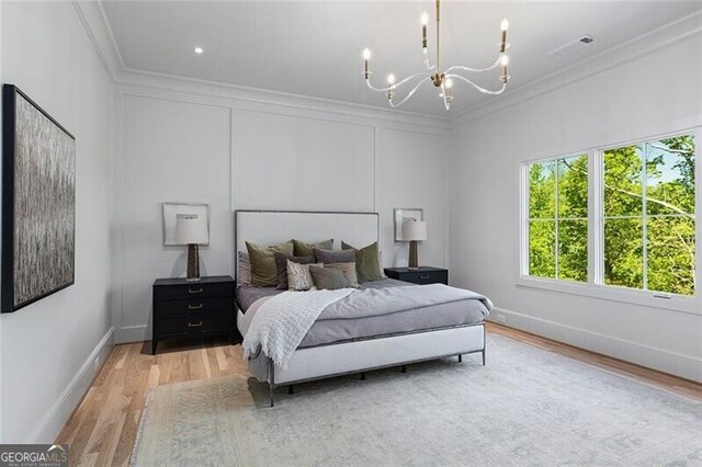 bedroom featuring a chandelier, wood finished floors, crown molding, and baseboards