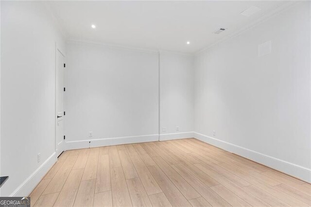 spare room featuring recessed lighting, light wood-style flooring, crown molding, and baseboards
