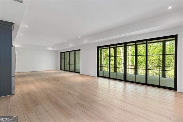 unfurnished living room featuring plenty of natural light, baseboards, recessed lighting, and light wood-style floors