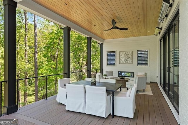 sunroom with outdoor dining area, plenty of natural light, and a ceiling fan