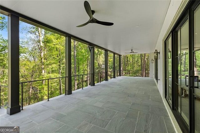 unfurnished sunroom featuring a ceiling fan