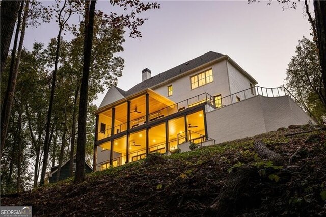 back of property with a chimney and a balcony