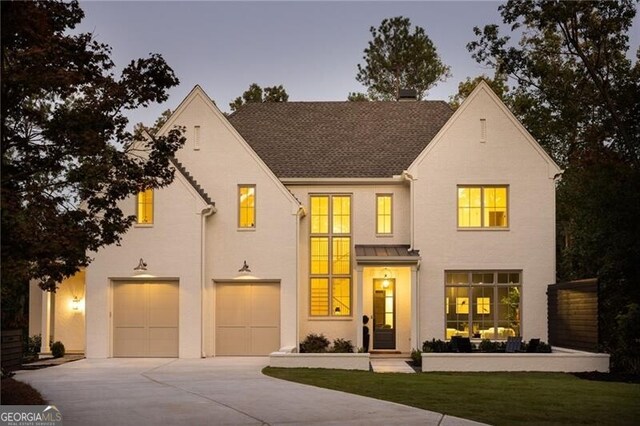 view of front of home featuring stucco siding, driveway, and a garage