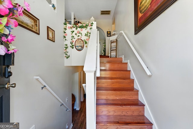 1010 Augusta Woods Dr, Douglasville, GA 30134 - staircase featuring arched walkways, wood finished floors, and visible vents