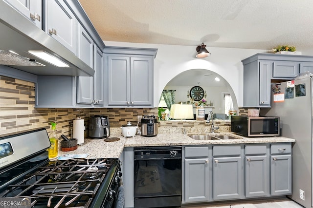 1010 Augusta Woods Dr, Douglasville, GA 30134 - kitchen with a sink, arched walkways, appliances with stainless steel finishes, under cabinet range hood, and gray cabinetry