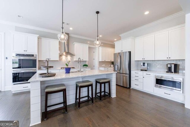 4405 Croftshire Pl, Cumming, GA 30040 - kitchen with wall chimney exhaust hood, appliances with stainless steel finishes, a sink, baseboards, and a breakfast bar area