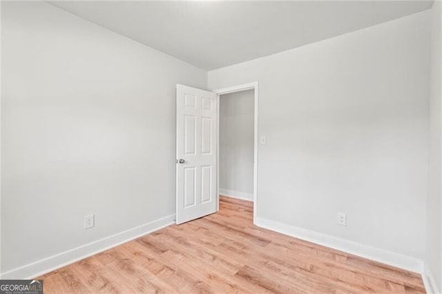 spare room with light wood-style flooring and baseboards