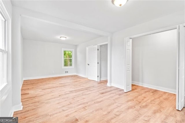 unfurnished bedroom featuring light wood-style flooring, visible vents, and baseboards