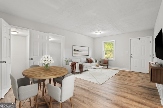dining area featuring baseboards and light wood-style floors