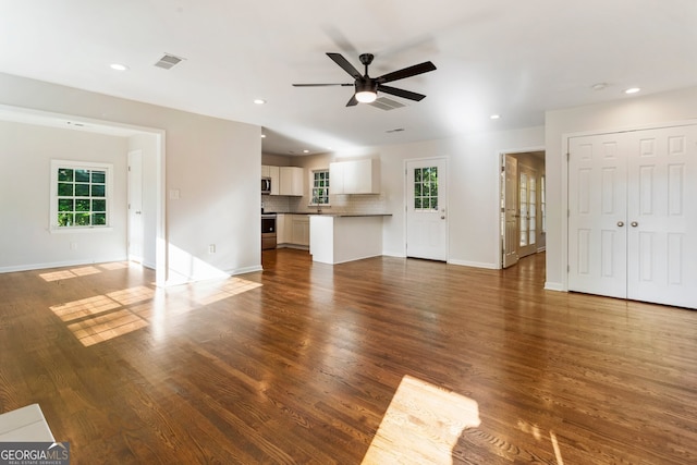 1541 Pontiac Pl SE, Atlanta, GA 30315 - unfurnished living room with ceiling fan, baseboards, wood finished floors, and plenty of natural light