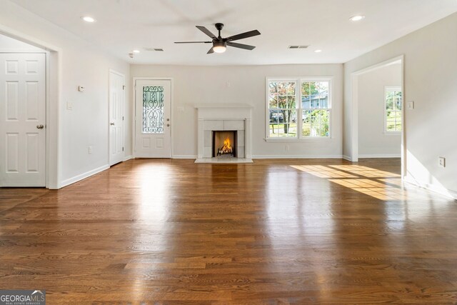 1541 Pontiac Pl SE, Atlanta, GA 30315 - unfurnished living room with a fireplace with flush hearth, baseboards, visible vents, a ceiling fan, and wood finished floors