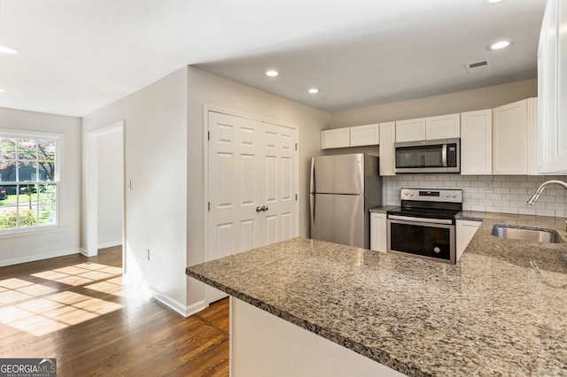 1541 Pontiac Pl SE, Atlanta, GA 30315 - kitchen featuring stainless steel appliances, a sink, dark wood finished floors, stone counters, and baseboards