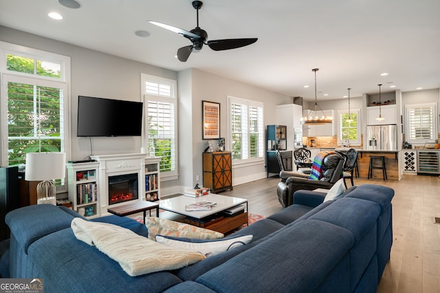986 Mauldin St SE, Atlanta, GA 30316 - living room with a glass covered fireplace, beverage cooler, ceiling fan, recessed lighting, and light wood-style flooring