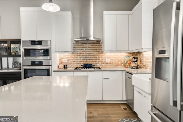 986 Mauldin St SE, Atlanta, GA 30316 - kitchen featuring light countertops, appliances with stainless steel finishes, wall chimney exhaust hood, and white cabinetry