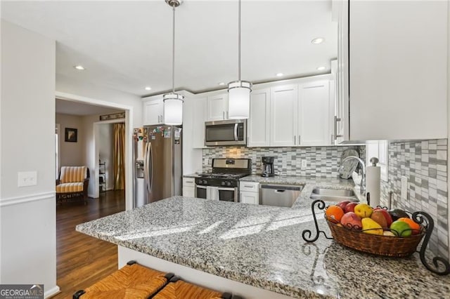 kitchen featuring a sink, white cabinetry, decorative backsplash, light stone countertops, and appliances with stainless steel finishes