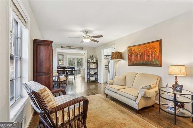 living area featuring wood finished floors and ceiling fan