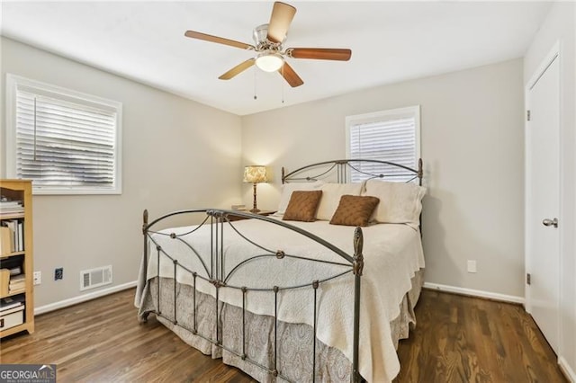bedroom with wood finished floors, visible vents, baseboards, and ceiling fan