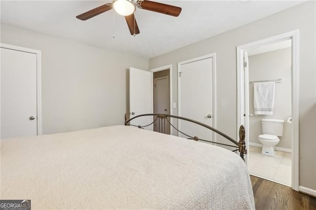 bedroom with wood finished floors, connected bathroom, and ceiling fan
