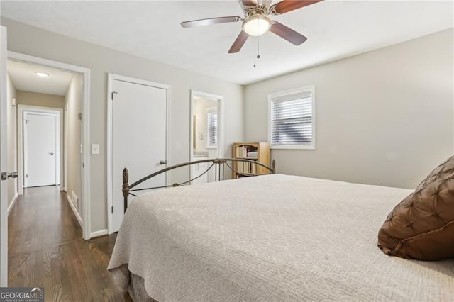 bedroom featuring baseboards, a ceiling fan, and dark wood-type flooring