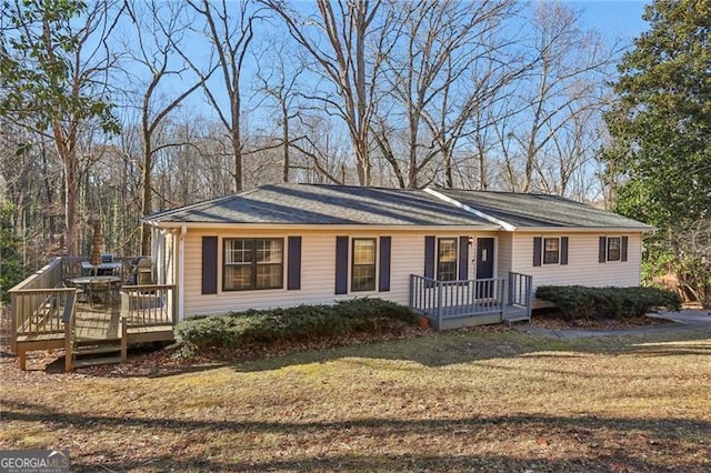 view of front of house featuring a front lawn and a deck