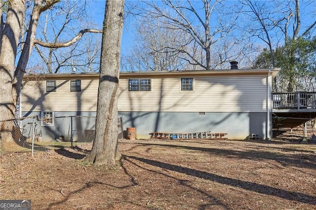 back of house with crawl space and a deck
