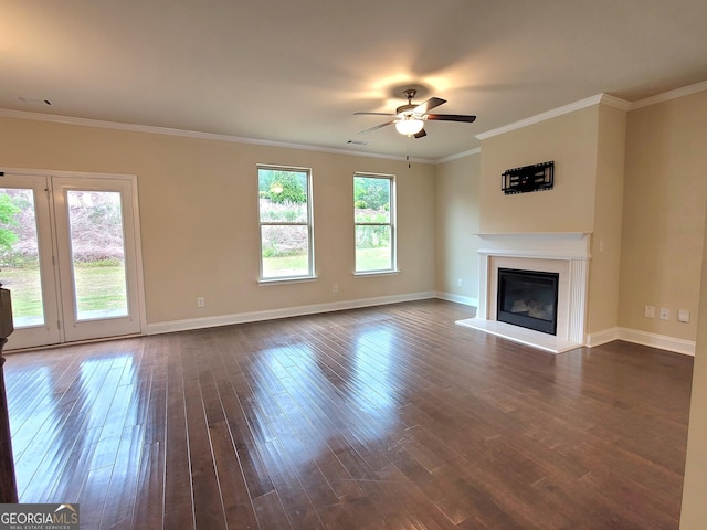 unfurnished living room featuring crown molding, a glass covered fireplace, ceiling fan, baseboards, and dark wood-type flooring