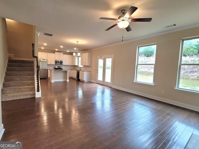 unfurnished living room with visible vents, baseboards, and ornamental molding
