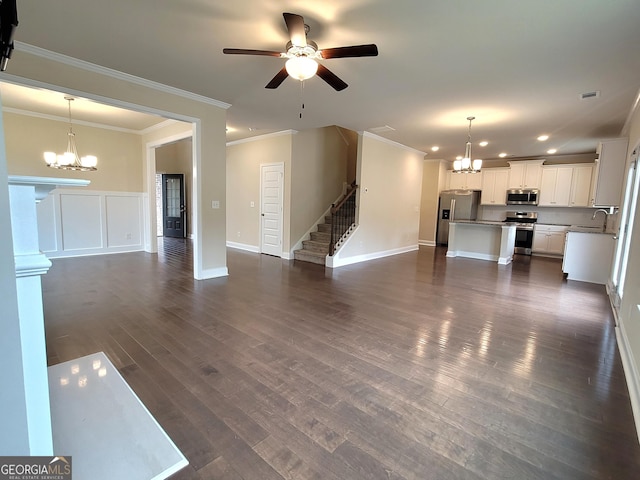 unfurnished living room featuring stairway, crown molding, a sink, and recessed lighting