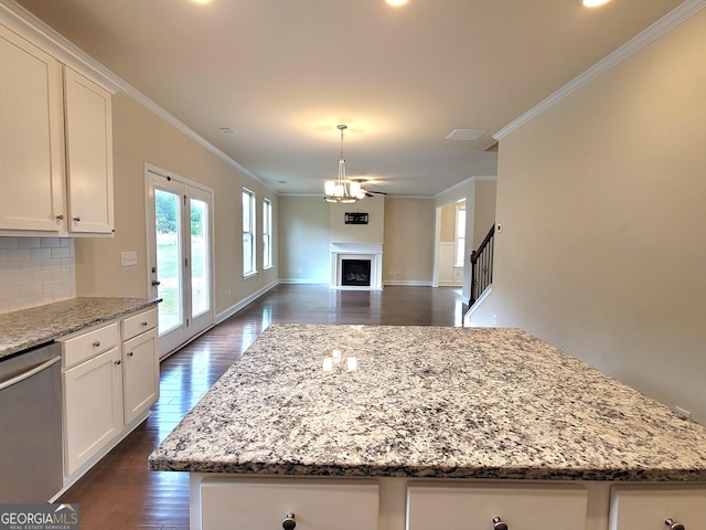 kitchen featuring open floor plan, stainless steel dishwasher, dark wood-type flooring, and ornamental molding